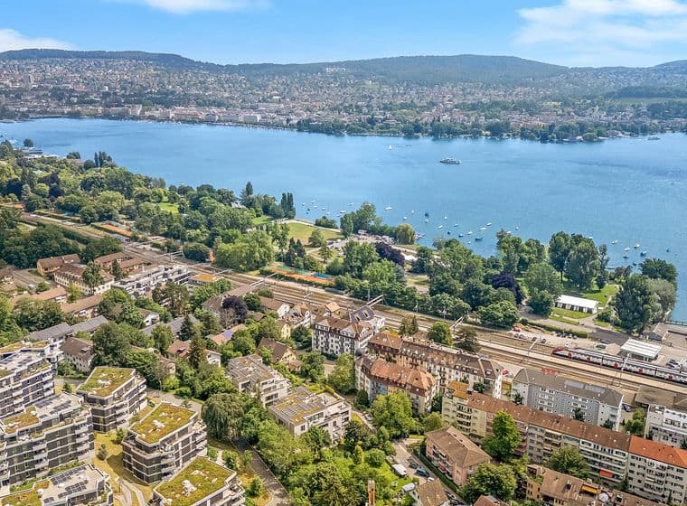 Aerial view of Zurich’s Seefeld district with Lake Zurich, surrounding green parks, and residential buildings in the foreground.