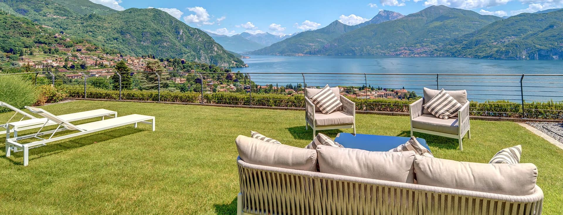 Garten mit Loungemöbeln im Außenbereich und Panoramablick auf den Comer See und die Berge, in Menaggio.