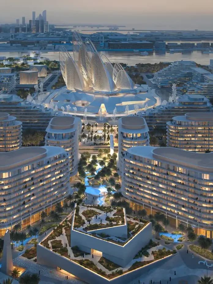 Aerial view of a futuristic cityscape at dusk with illuminated, curvy modern buildings, lush greenery, and waterfront in the background.