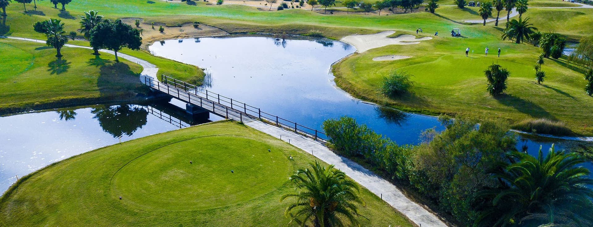 Vista aèria d'un camp de golf a Torrevieja. Es veu un llac i diferents parts del camp de golf amb arbres.