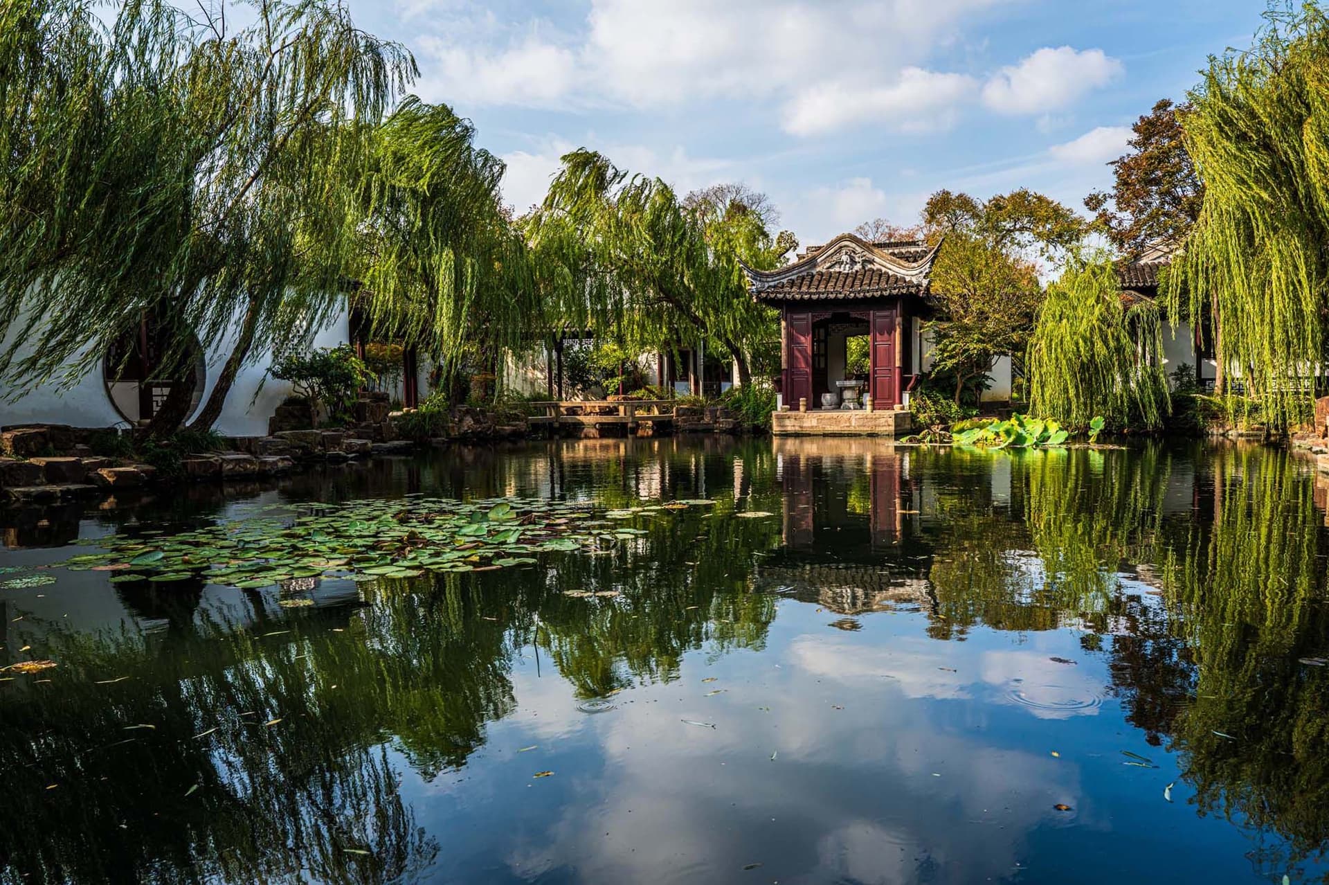 A traditional Chinese garden with curved bridges, pavilions, ponds and artistically designed nature in the classical gardens of Suzhou, China.