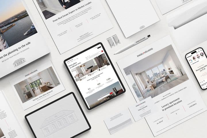 Visão aérea de materiais de marketing imobiliário da Engel & Völkers, incluindo brochuras, tablet e telefone.