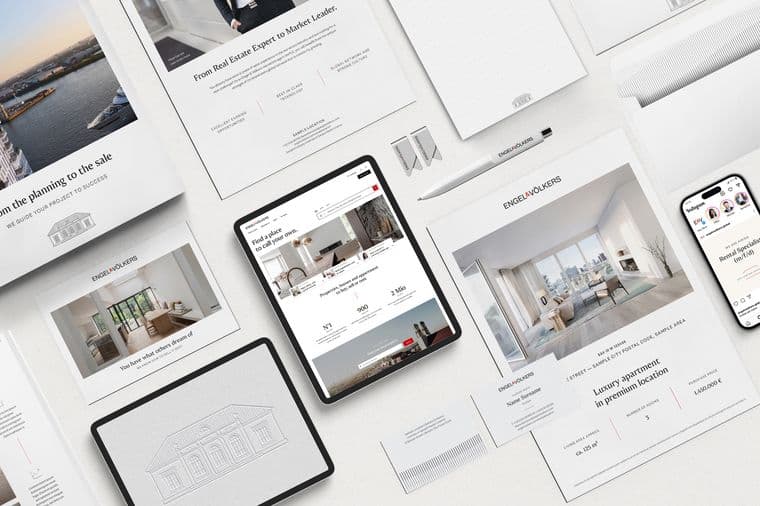 Overhead shot of Engel & Völkers real estate marketing materials, including brochures, tablet, and phone.