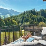 Terrace of a high-end chalet with lounge furniture and a view of the Kitzbühel mountain landscape.