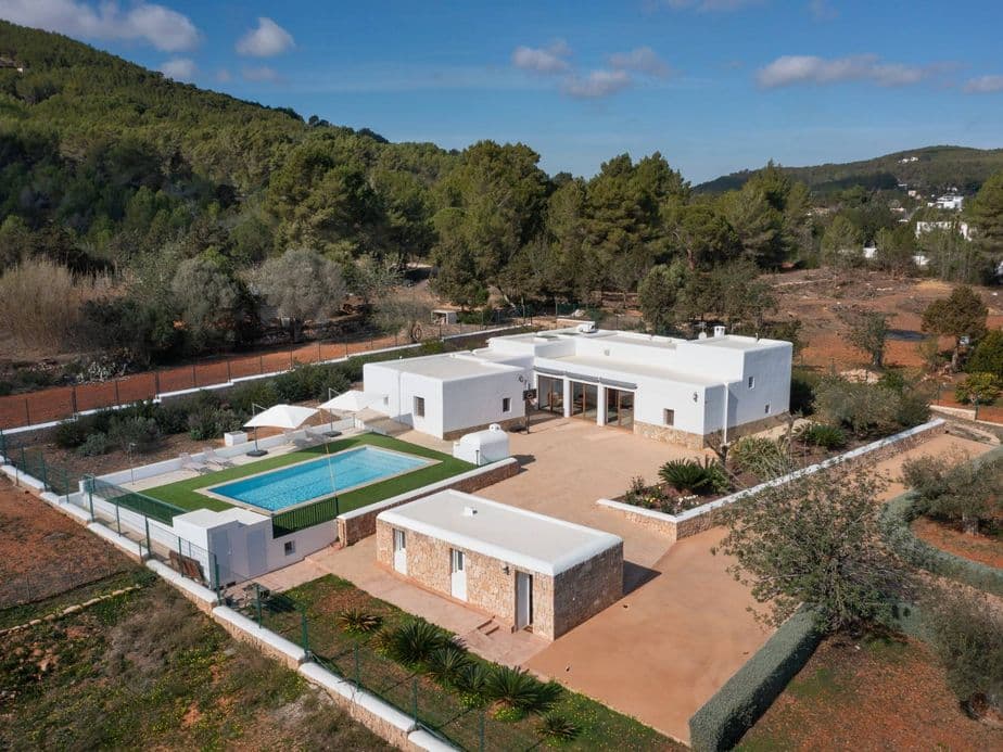 Aerial view of a white finca with pool in eastern Ibiza, nestled in the countryside and surrounded by natural greenery.