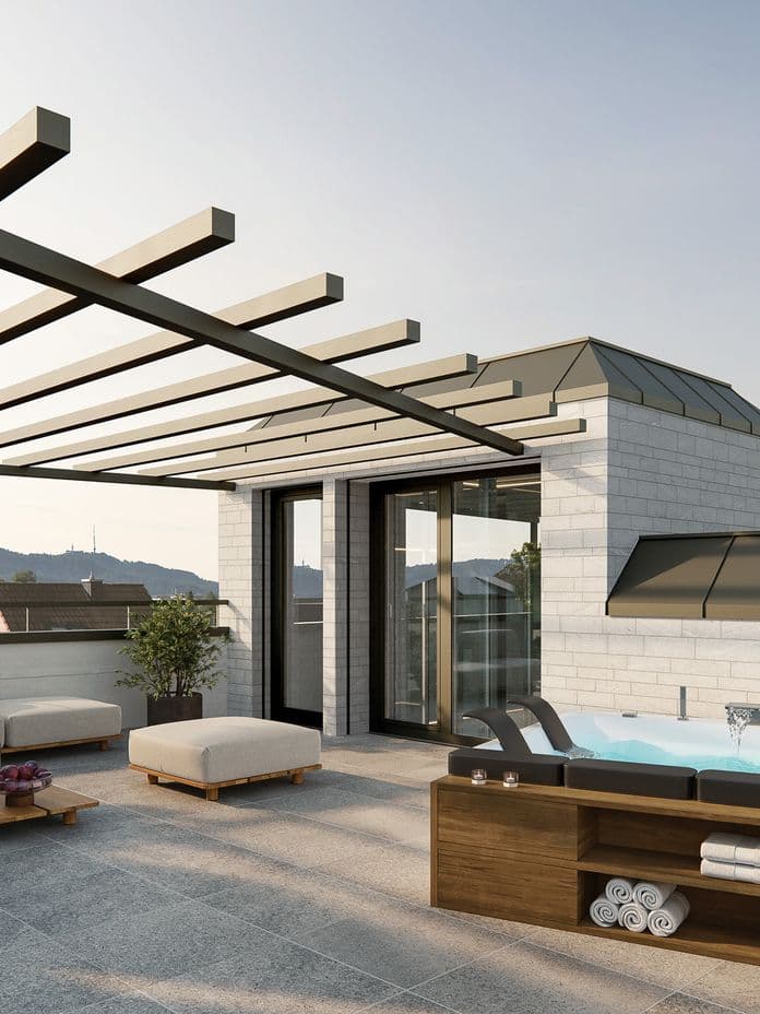 Moderne Dachterrasse mit Pergola, gepolsterten Sitzgelegenheiten, Whirlpool und Pflanzen. Mit Blick auf eine malerische Landschaft mit klarem Himmel und Hügeln.