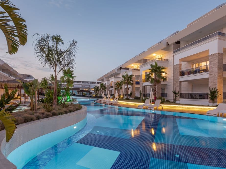Modern hotel resort in Mallorca with pool area, palm trees, and Mediterranean-style architecture