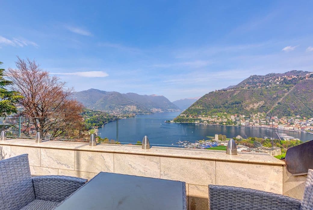 Dachterrasse mit Sitzgruppe und Panoramablick auf den Comer See und die umliegenden Berge