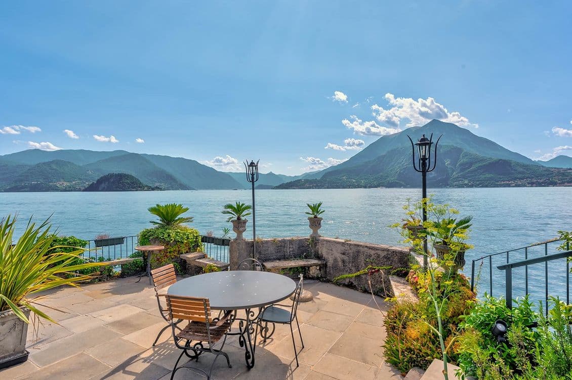 Terrasse mit Tisch, Stühlen und Panoramablick auf den Comer See und die Berge