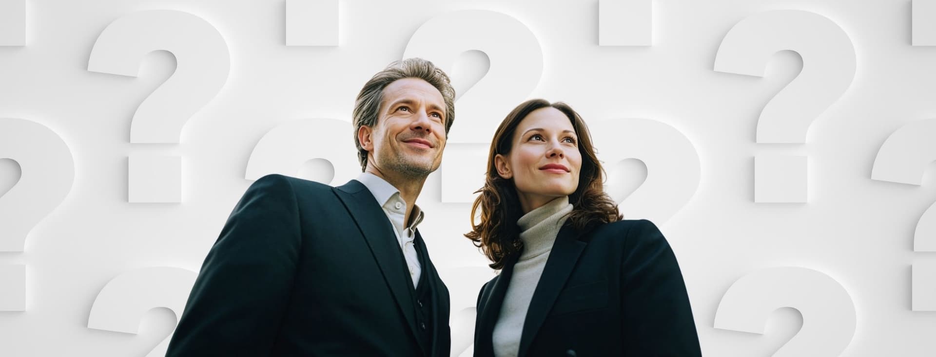Ein Mann und eine Frau in Business-Kleidung blicken selbstbewusst nach oben, während sie vor einem Hintergrund aus großen weißen Fragezeichen stehen.