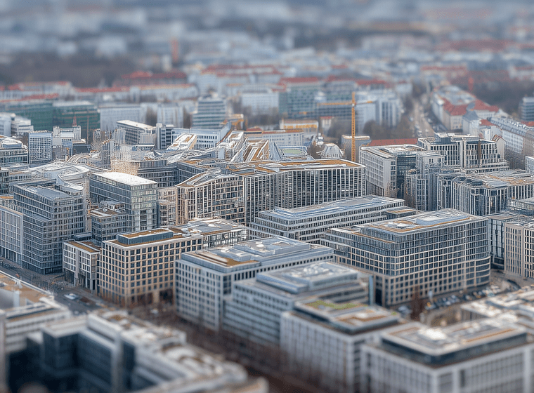 Aerial view of a cityscape with modern buildings, residential areas, and streets, showcasing a densely populated urban environment.