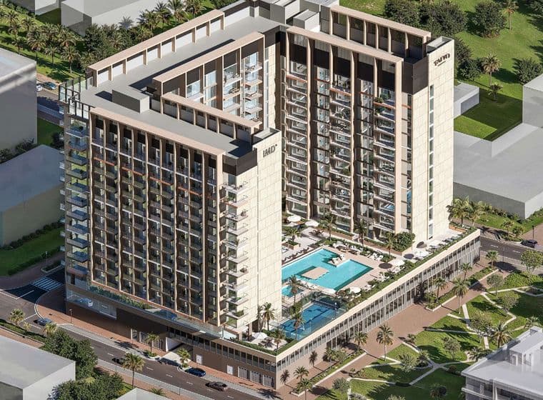 Aerial view of Taiyo Residences, a U-shaped mid-rise residential complex with a central pool deck, modern façade, and landscaped surroundings in Wasl Gate, Dubai.