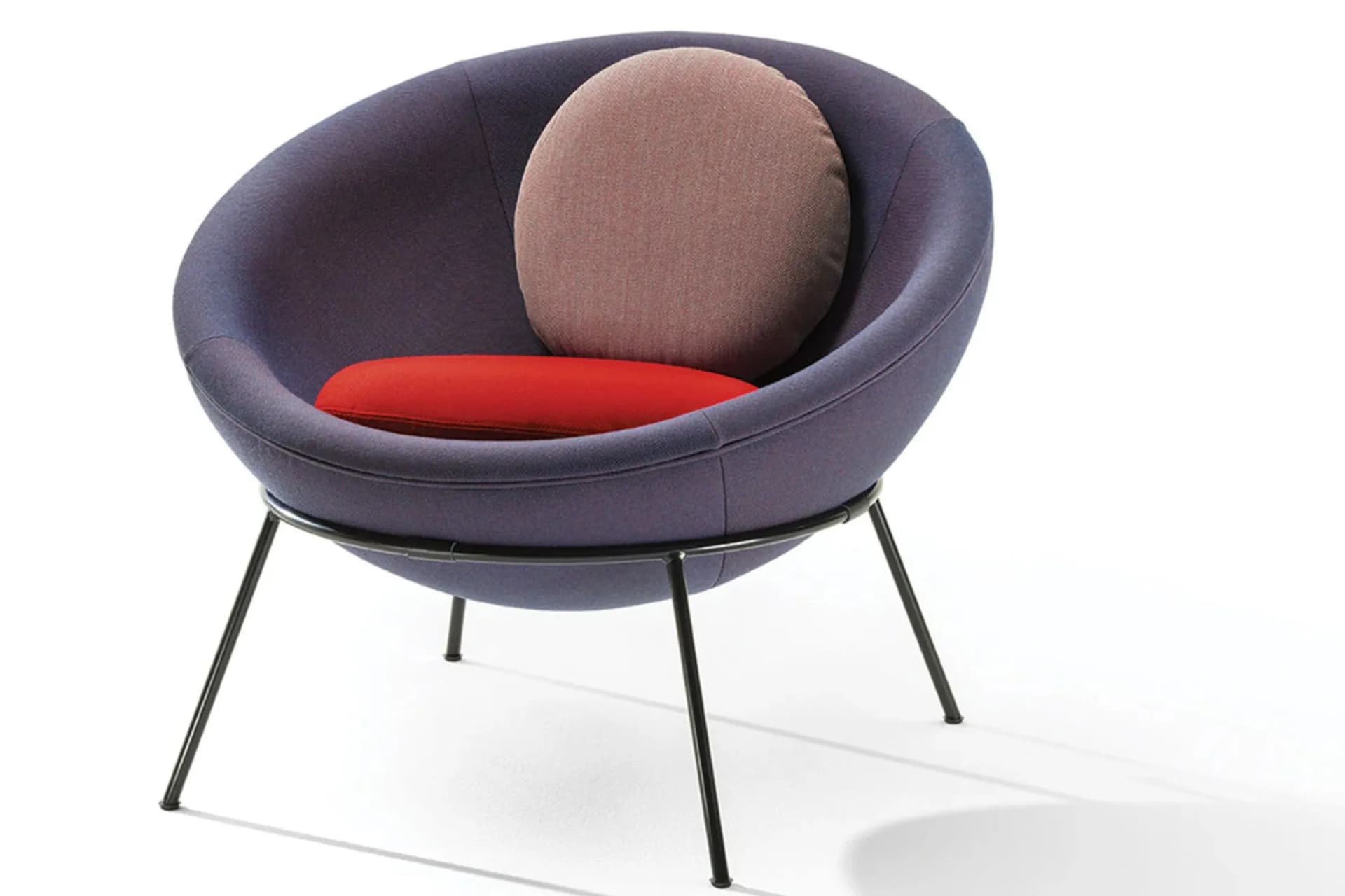 Modern round purple lounge chair with a beige circular back cushion and a red seat cushion on slender black metal legs.