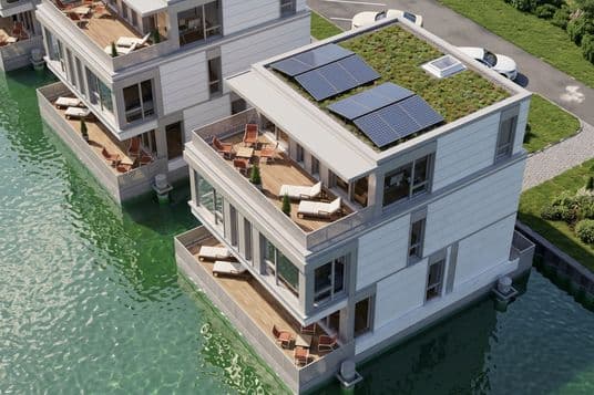 Waterfront modern apartment with stacked balconies, lounge chairs and a planted rooftop with solar panels.