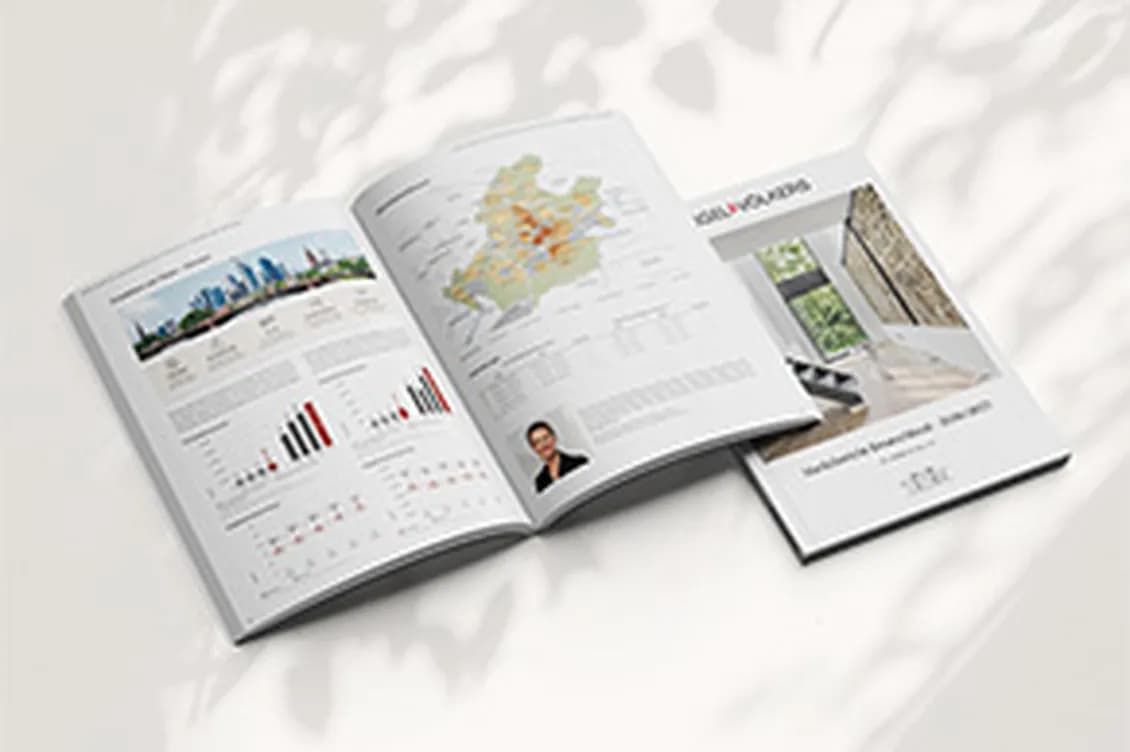 Open business magazine spread featuring a world map, charts, and a small brochure on a light, sunlit surface.