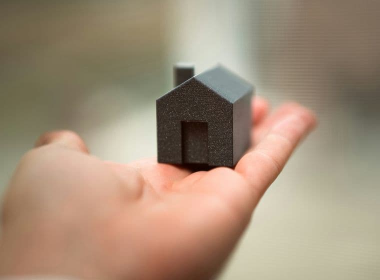 Una mano sosteniendo una casita de juguete