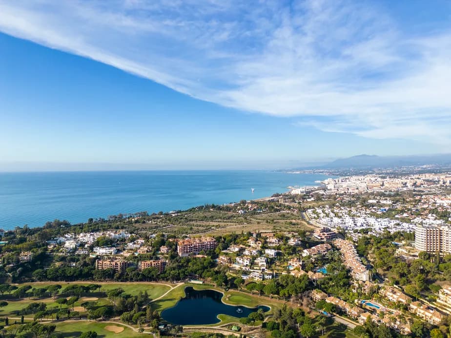 Aerial view of Marbella East with a golf course and the sea