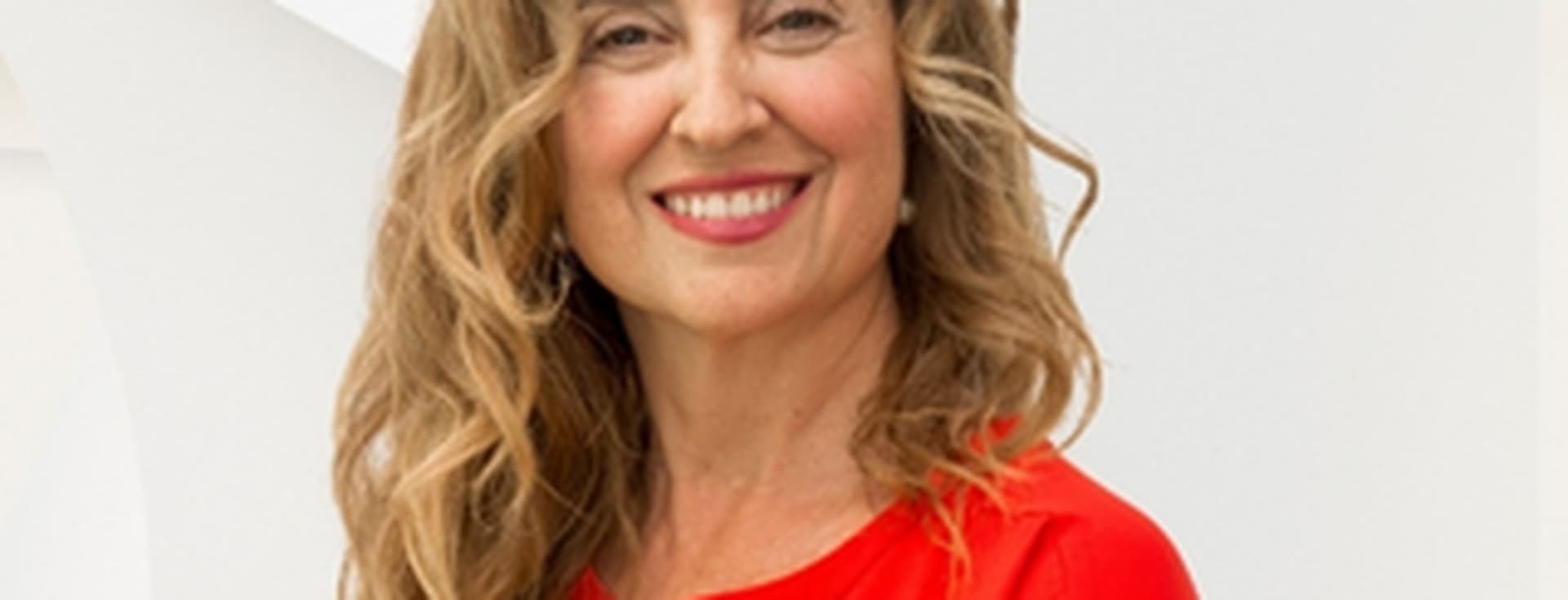 Woman dressed in red, with blonde hair, luxury real estate agent at Engel & Völkers