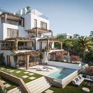 Moderne weiße Villa im mediterranen Stil mit mehreren Terrassen, Infinity-Pool, angelegten Gärten mit Palmen, Steinmauern und zeitgenössischer kubischer Architektur vor blauem Himmel.