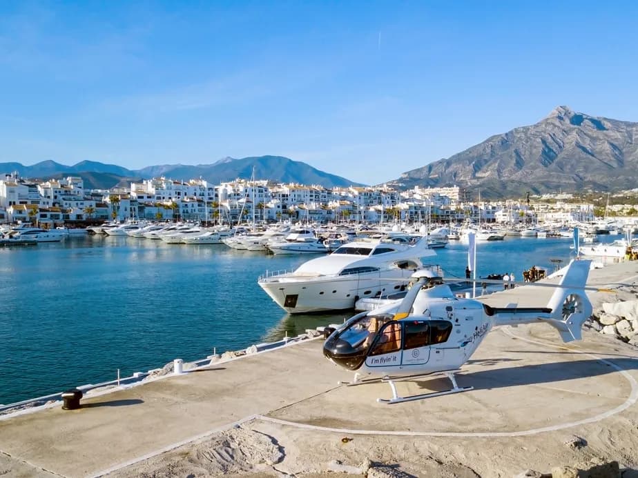 Heliport in puerto banús, next to the harbour with many boats and luxurious shops, with La Concha mountain in the background