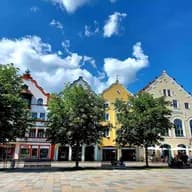 Blick auf den Marienplatz in Weilheim mit bunten historischen Giebelhäusern, Straßencafés und lebendiger Altstadtatmosphäre