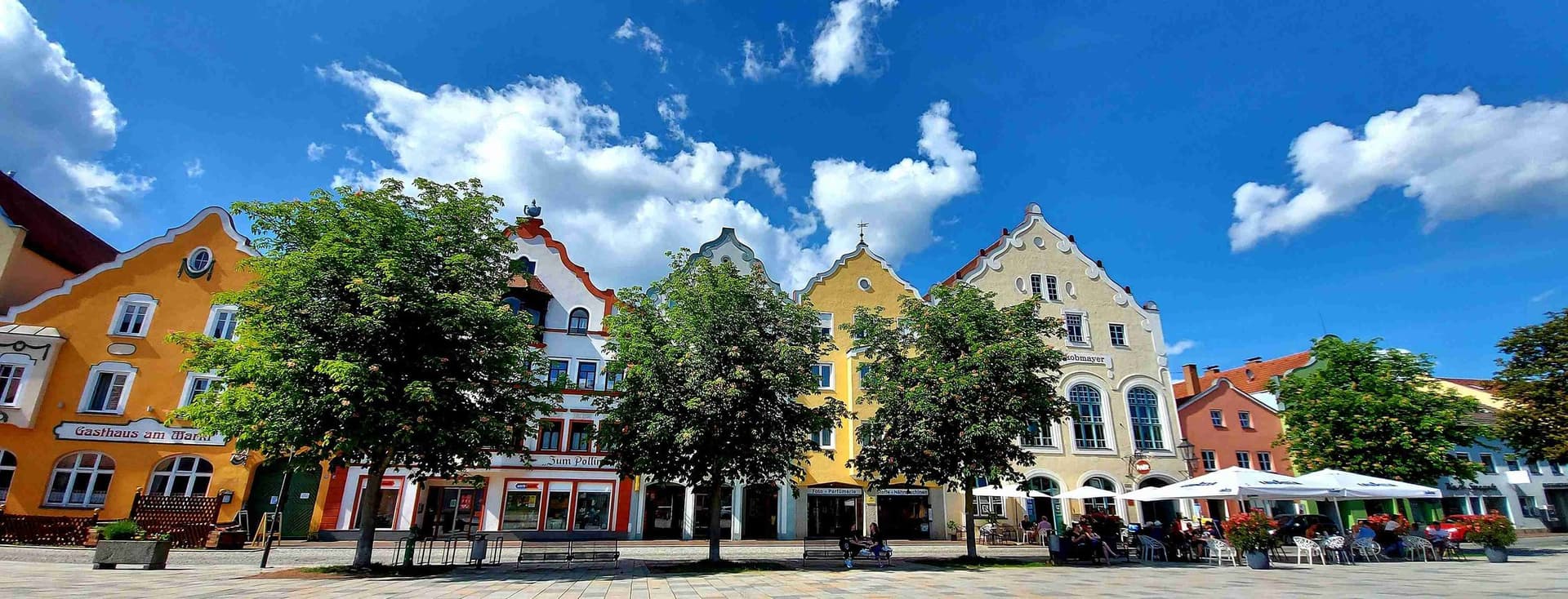 View of Marienplatz in Weilheim, Germany, with colorful historic gabled houses, street cafés and lively old town atmosphere