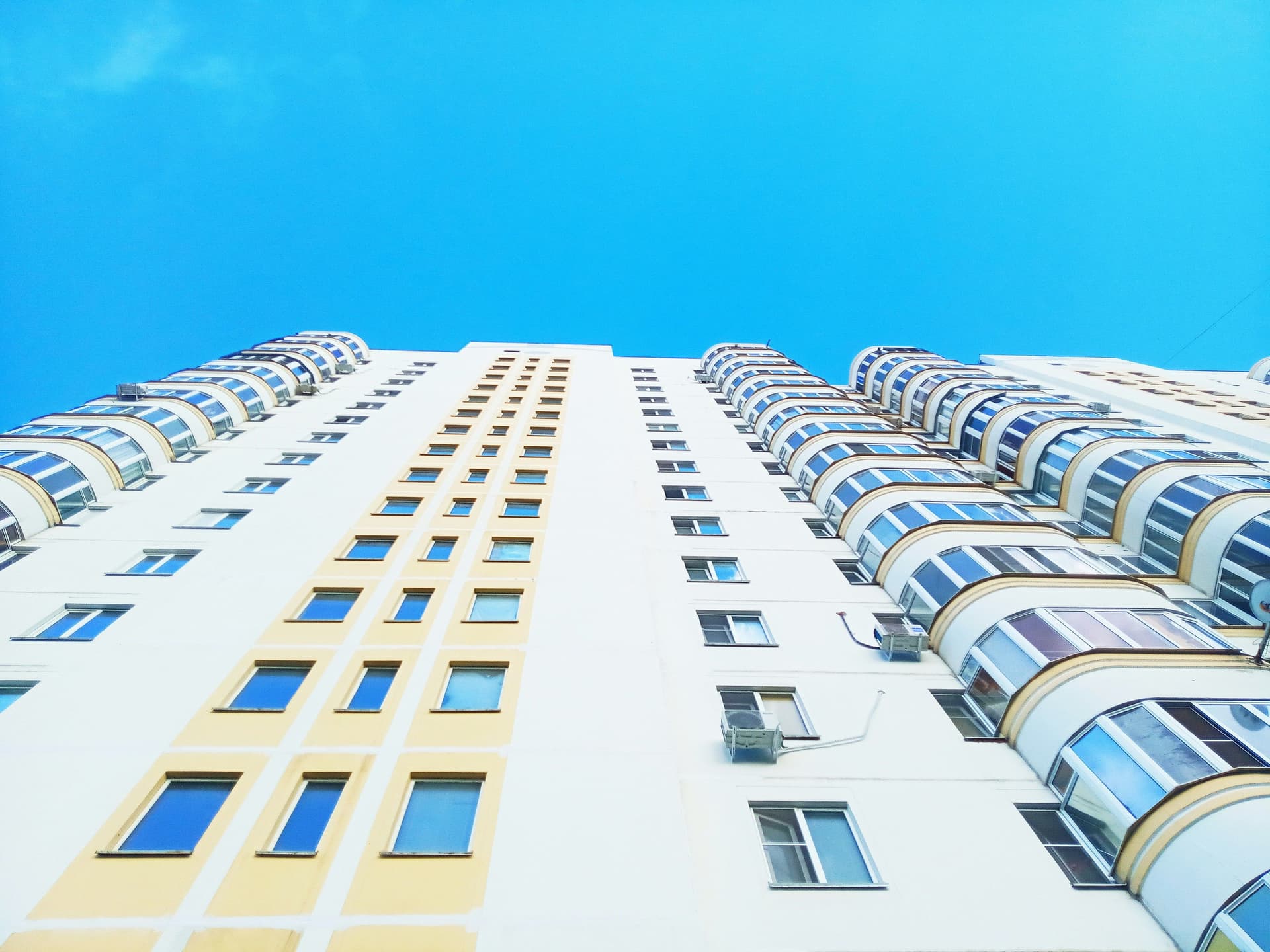 edificio visto desde abajo, con mucha altura, muchos pisos y ventanas sin balcones