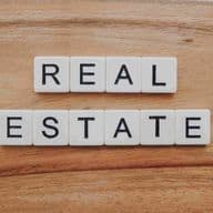 Texto agente inmobiliario en inglés escrito sobre una mesa