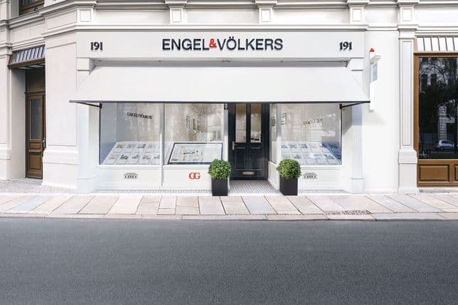 Engel & Völkers real estate office at 191, with a white awning, large windows, and potted plants flanking the entrance.