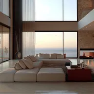 Modern living room with a white sectional sofa, floor-to-ceiling windows and a stone fireplace, overlooking the ocean at sunset.