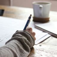 Una mujer escribiendo sobre una hoja