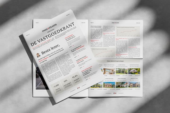 Monochrome image of a folded real estate newspaper titled DE VASTGOEDKRANT with Engel & Völkers branding, spread open.