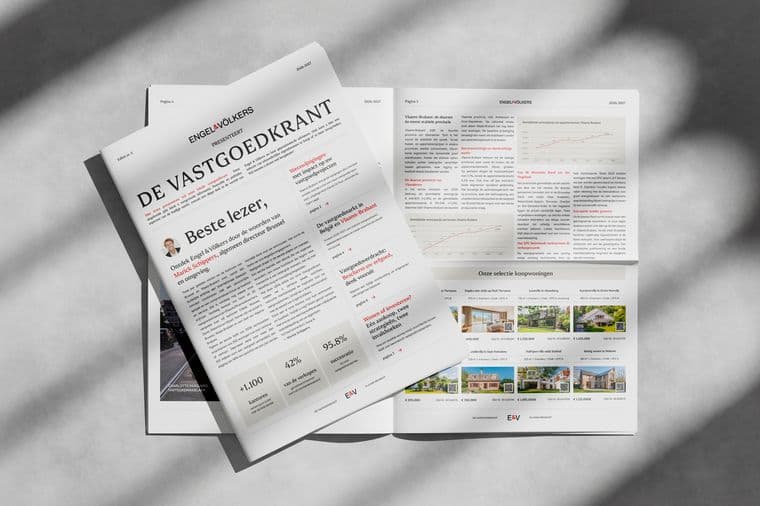 Monochrome image of a folded real estate newspaper titled DE VASTGOEDKRANT with Engel & Völkers branding, spread open.