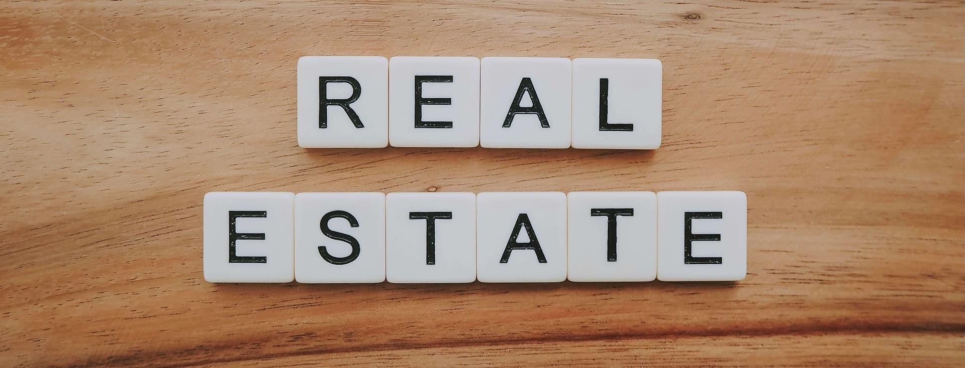 piezas tipo scrabble con las letras real estate