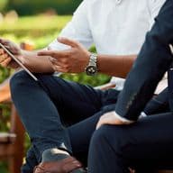 Dos hombres observando una tablet y conversando