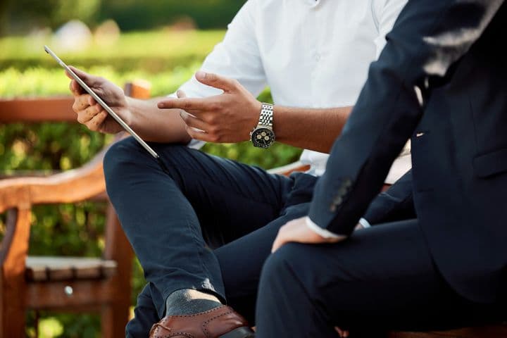 Dos hombres observando una tablet y conversando