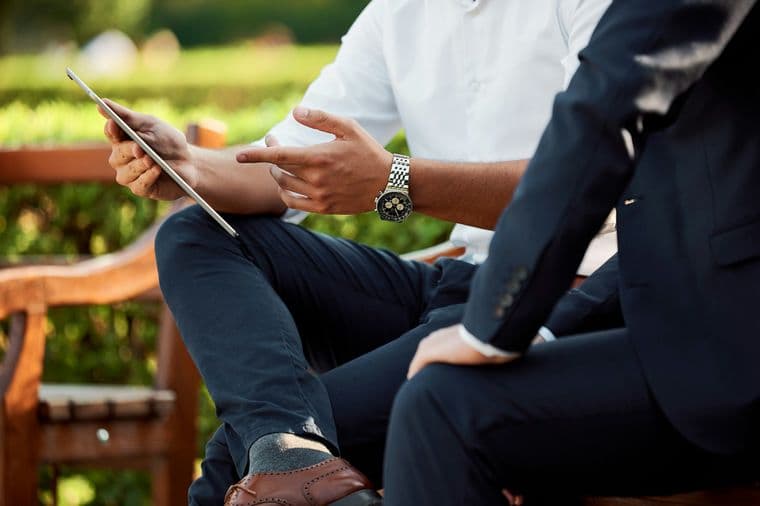 Dos hombres observando una tablet y conversando