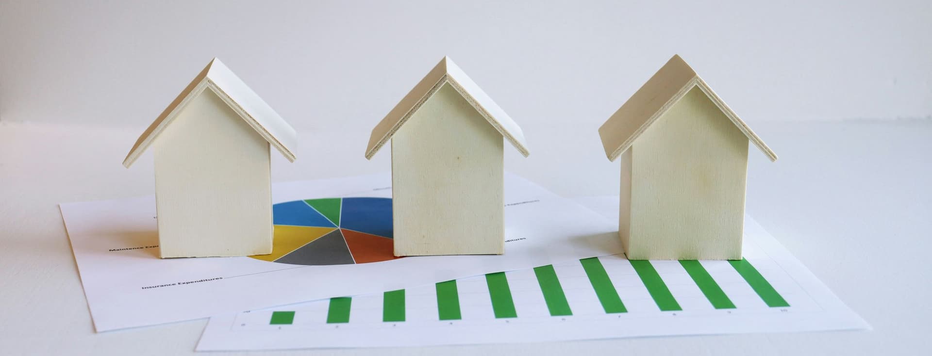 Casitas de madera sobre folios con gráficos y documentos