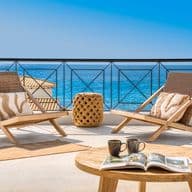 Terrace with two chairs and a small table overlooking the sea, typical of Menorca