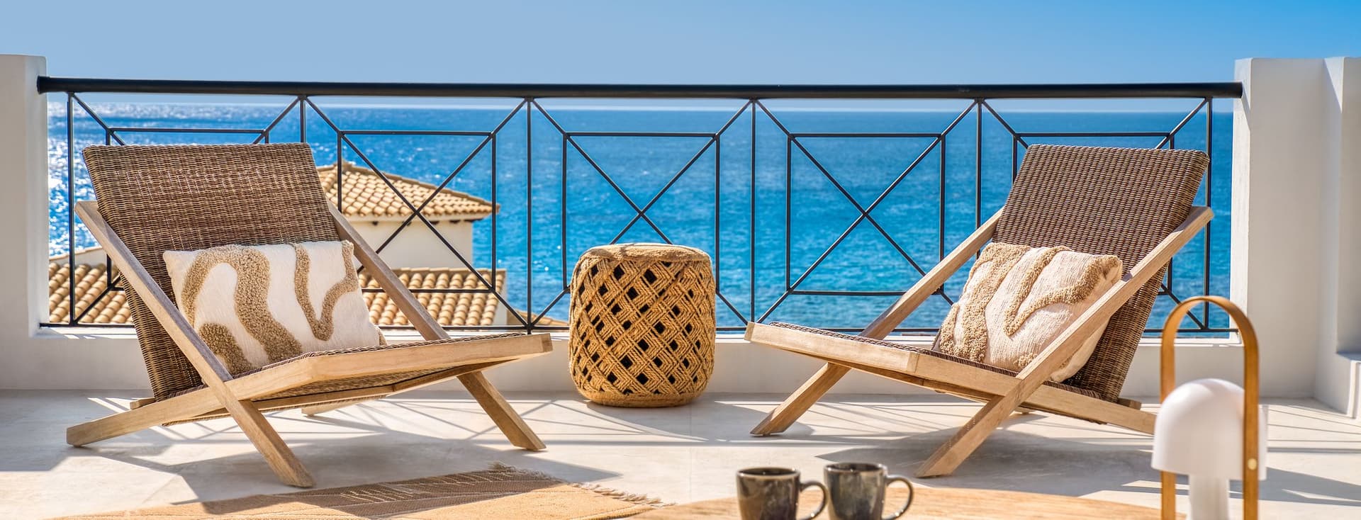 Terrace with two chairs and a small table overlooking the sea, typical of Menorca