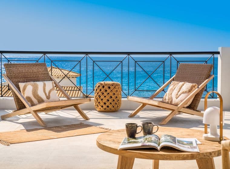 Terrace with two chairs and a small table overlooking the sea, typical of Menorca