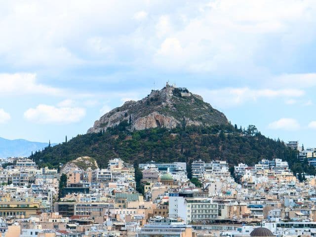 View of Lycabettus Hill rising above the Athens cityscape, one of the capital’s most iconic landmarks