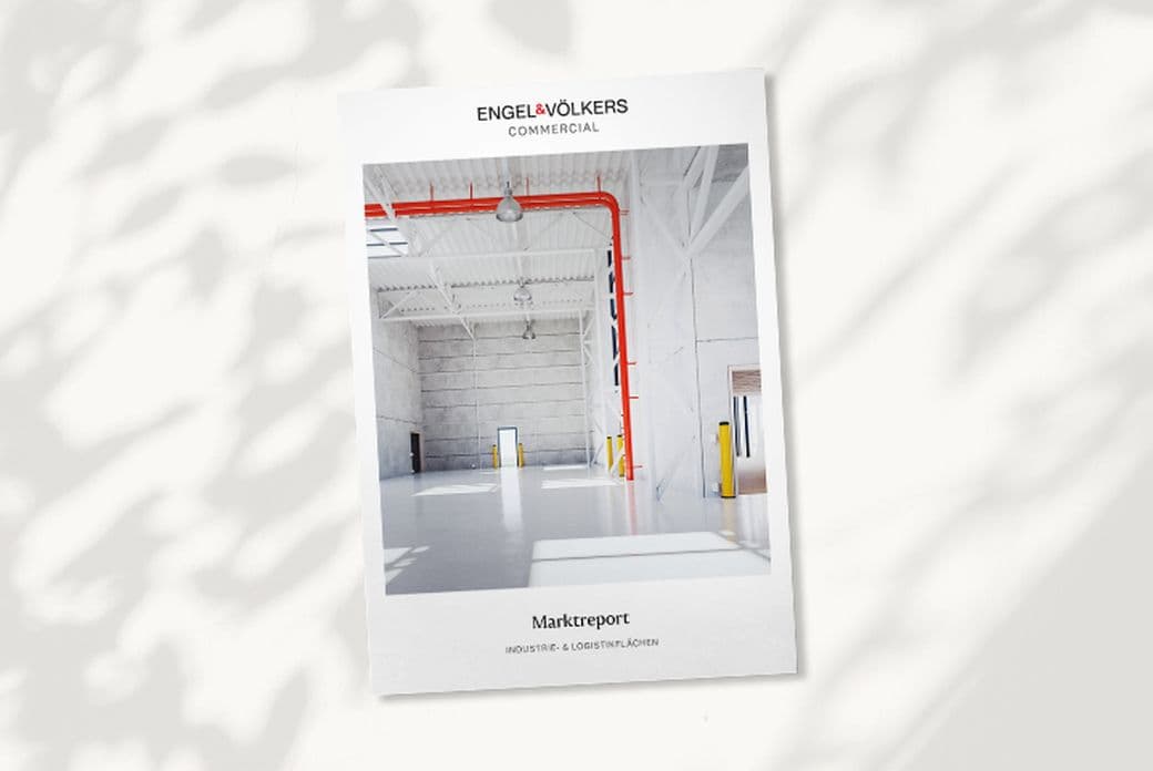 Cover of Engel & Völkers Commercial Market Report featuring an empty, well-lit industrial warehouse with a red pipe and high ceiling.
