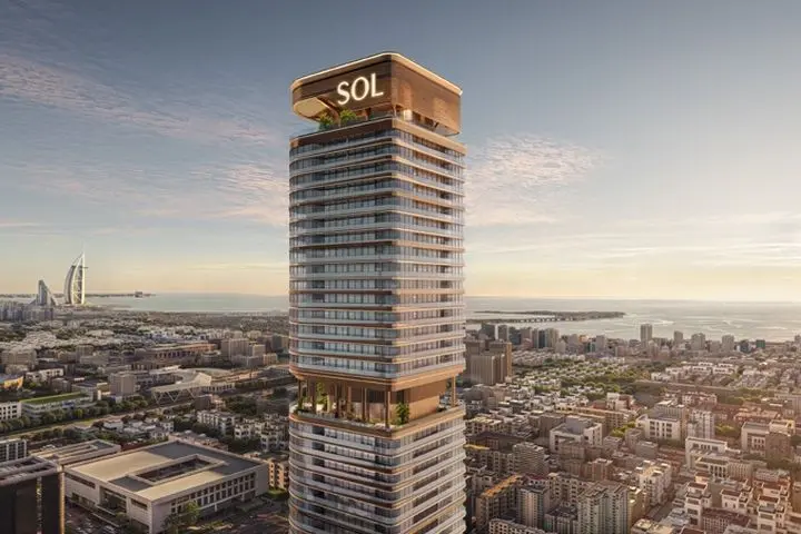 Tall modern skyscraper labeled "SOL" with terraces, overlooking a cityscape and ocean, with a famous sail-shaped hotel in the background.
