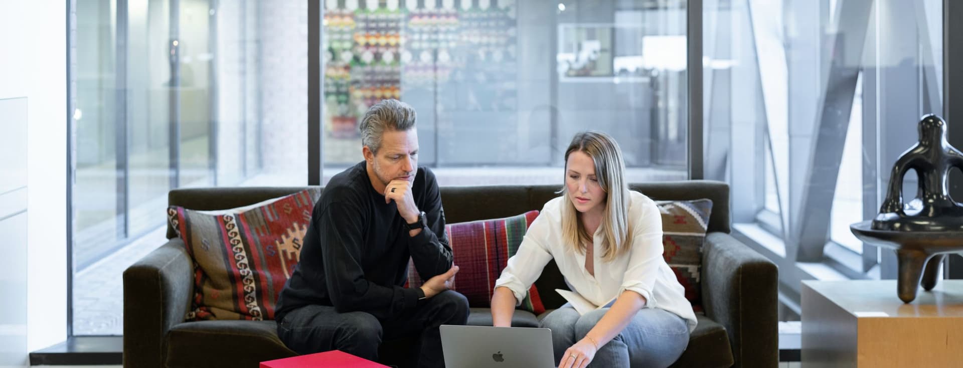 Dos personas mirando un portátil en una oficina