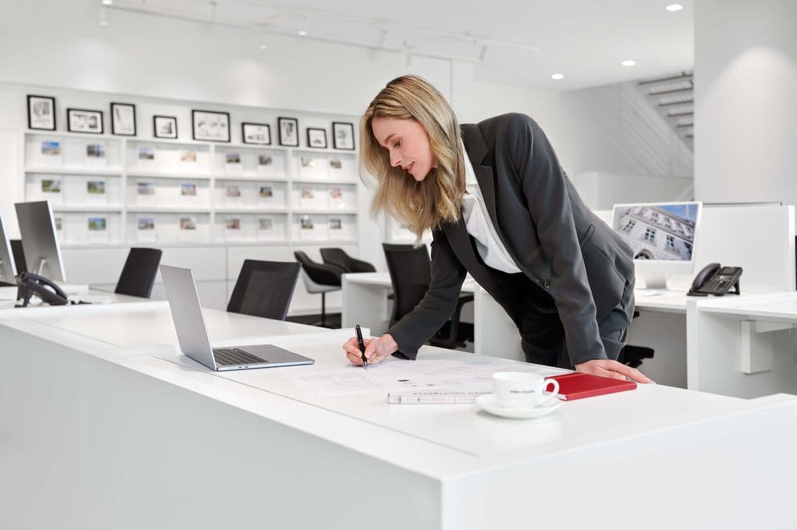 Immobilienmaklerin bei der Vorbereitung von Verkaufsunterlagen als Beispiel für die persönliche Begleitung beim Verkauf hochwertiger Immobilien im Hamburger Nordosten.